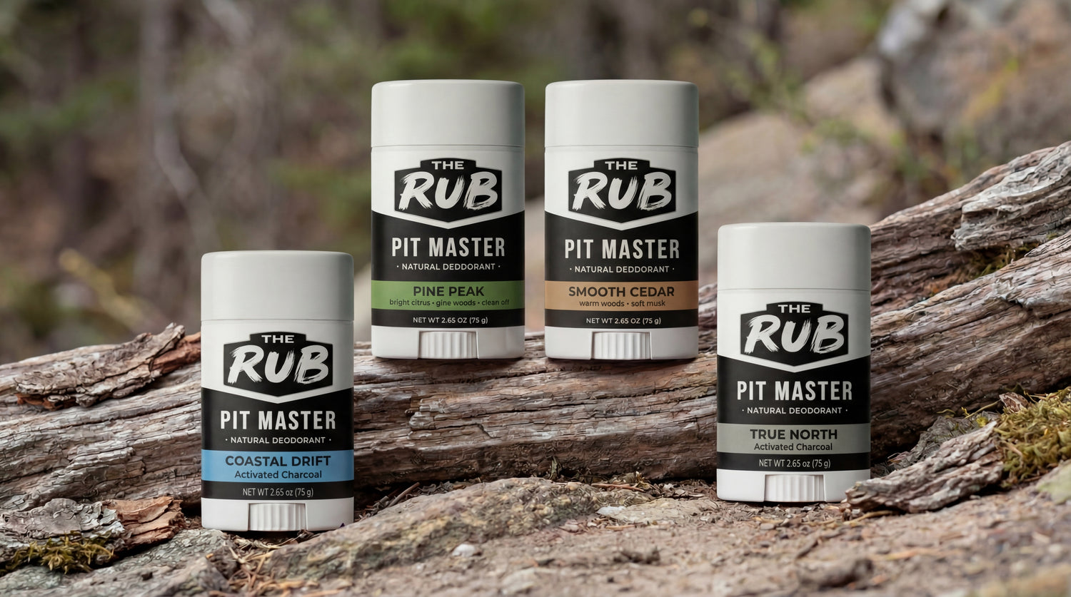 The image shows a group of four white deodorant sticks from a brand called THE RUB, specifically the PIT MASTER natural deodorant line.