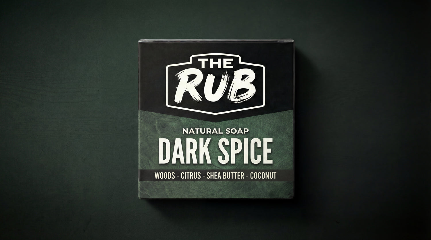 Dark Spice natural soap box by The Rub, highlighting ingredients like woods, citrus, shea butter, and coconut on a dark background.