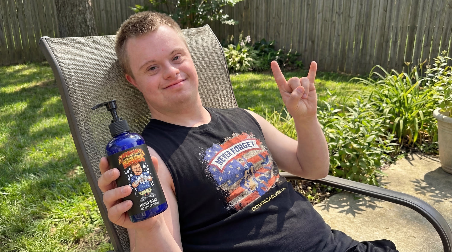 Drew from @down.rightdelicious lounging outdoors holding a bottle of his Wash My Damn Hands liquid soap.