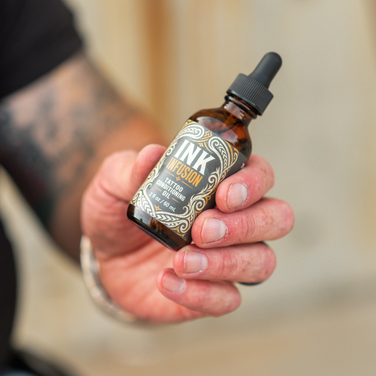 Picture of Dan, The Wheelchair Dad, holding his new tattoo conditioning oil, Ink Infusion