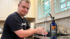 Drew from @down.rightdelicious washing his hands with the exclusive Wash My Damn Hands natural soap in a home kitchen.