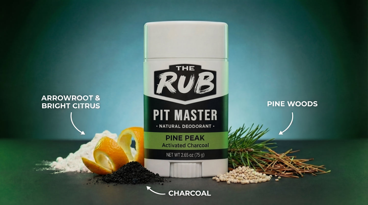Pine Peak natural deodorant by The Rub surrounded by ingredients: citrus peel, pine needles, arrowroot, and charcoal.
